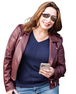 woman in leather jacket holding cell phone and smiling